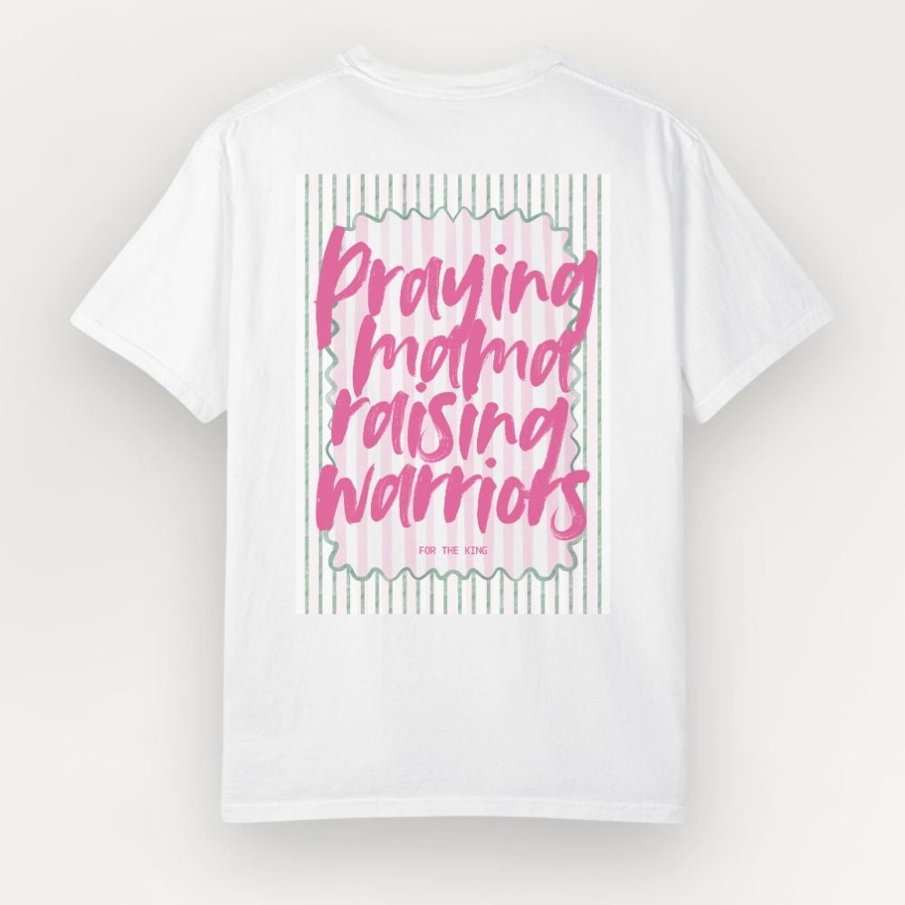 White t-shirt with pink text 'Praying mama raising warriors' on a light gray background
