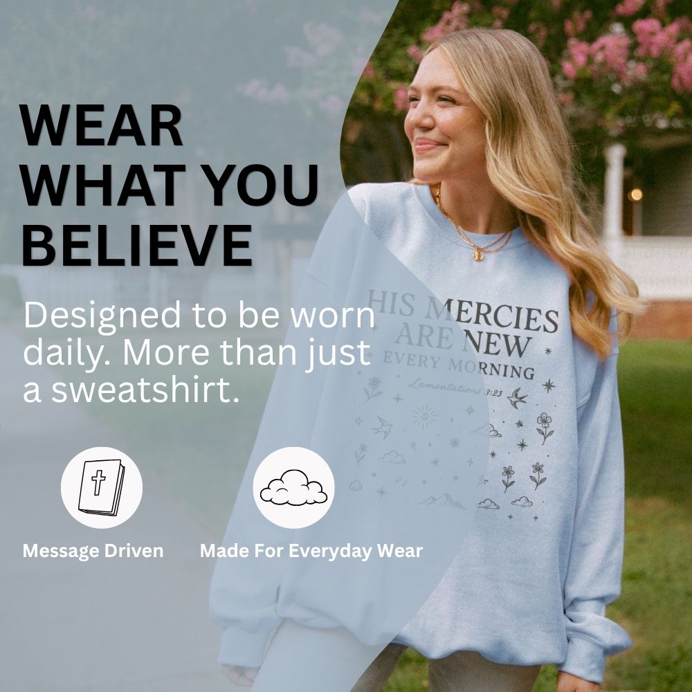 Woman wearing a sweatshirt with text and graphics, outdoors.