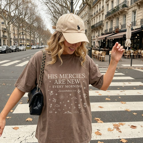 Woman wearing a brown t-shirt with text on a city street