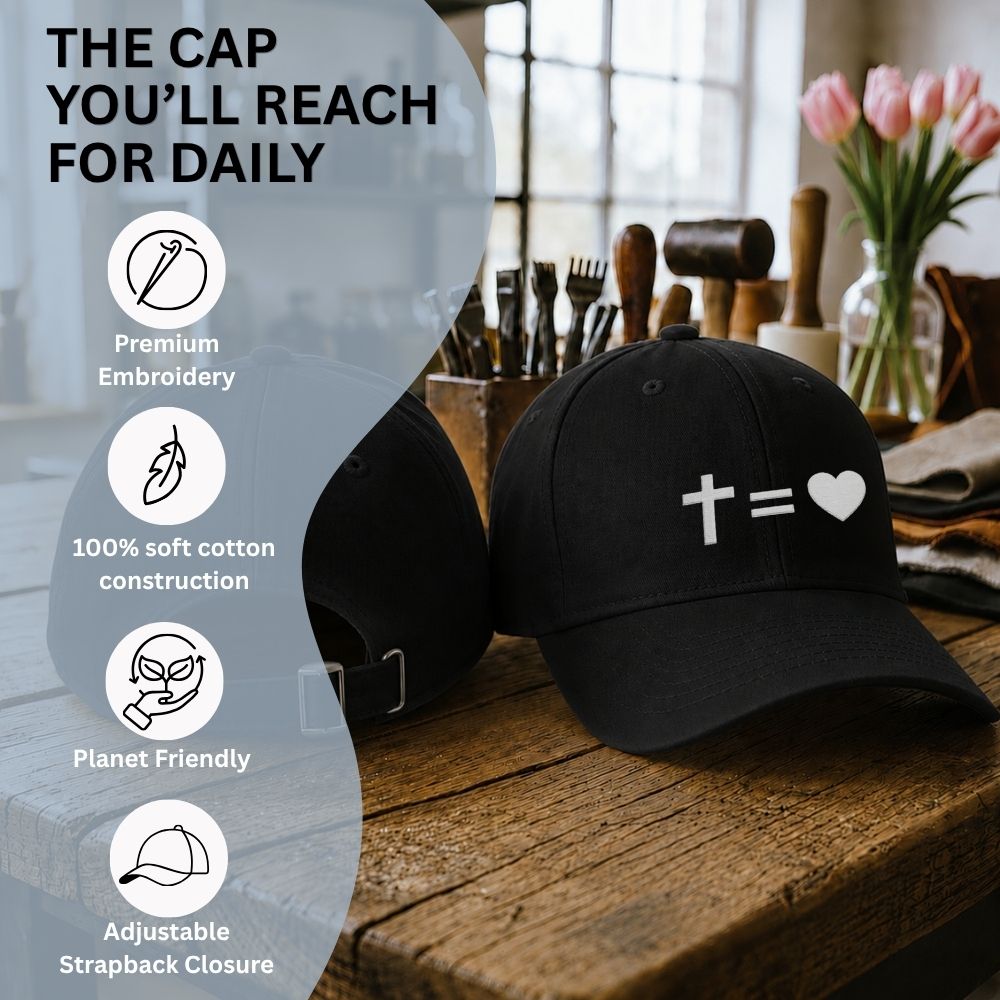 Black cap with a white symbol on a wooden surface with kitchen utensils and flowers.