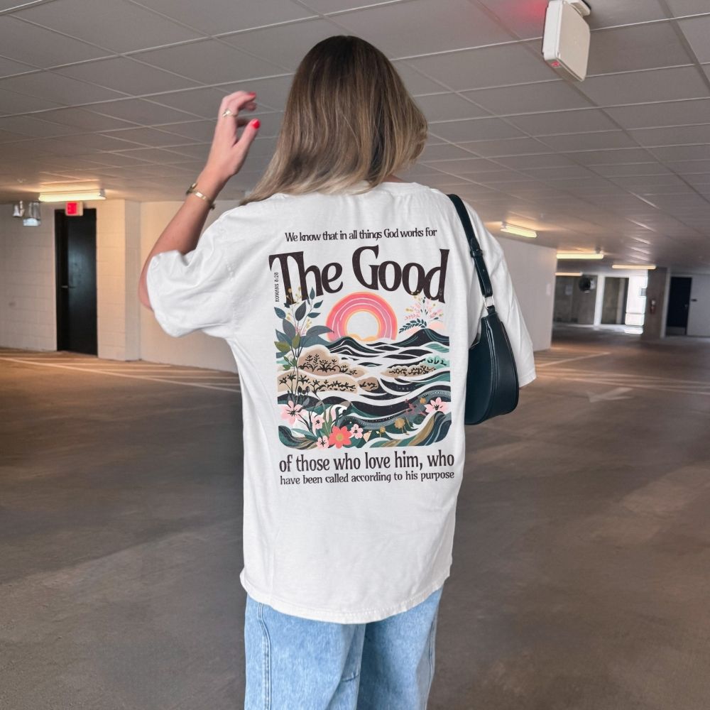 Person wearing a white t-shirt with a graphic design and text in an indoor setting