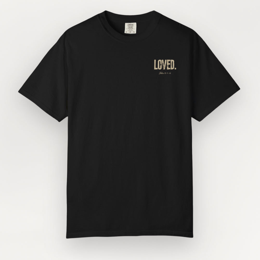 A black Everyday Faith short-sleeve Everyday Faith crewneck t-shirt with 'LOVED.' printed in a muted gold or beige serif font on the left chest, displayed against a light gray background.