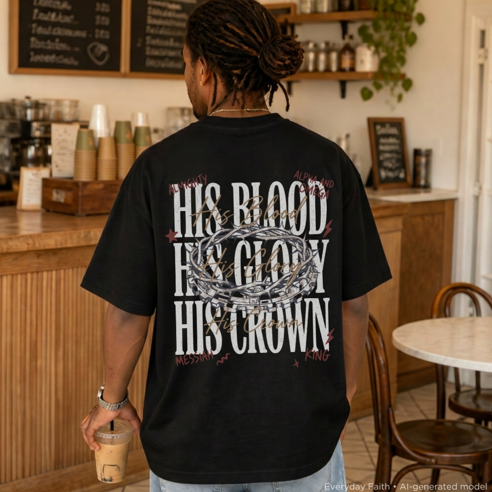 A man viewed from behind wearing a black Everyday Faith graphic t-shirt with white and silver text reading 'HIS BLOOD HIS GLORY HIS CROWN' in a cafe setting.