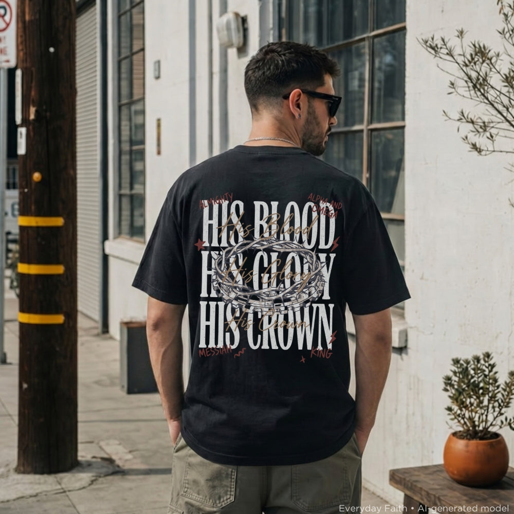 A man viewed from behind wearing a black Everyday Faith graphic t-shirt with a white and red 'His Blood, His Glory, His Crown' design, standing on an outdoor city sidewalk.