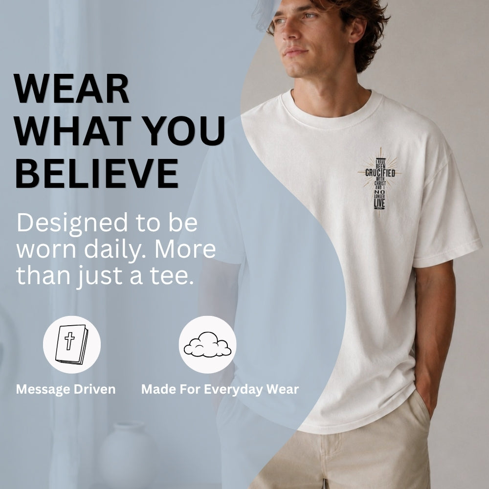 A man wearing a white Everyday Faith graphic t-shirt with a black cross design on the chest, standing against a neutral light gray background. The left side of the image features a large light blue overlay with text that reads 'WEAR WHAT YOU BELIEVE' and 'Designed to be worn daily.