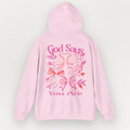 Pink hoodie with decorative text and designs on a light gray background