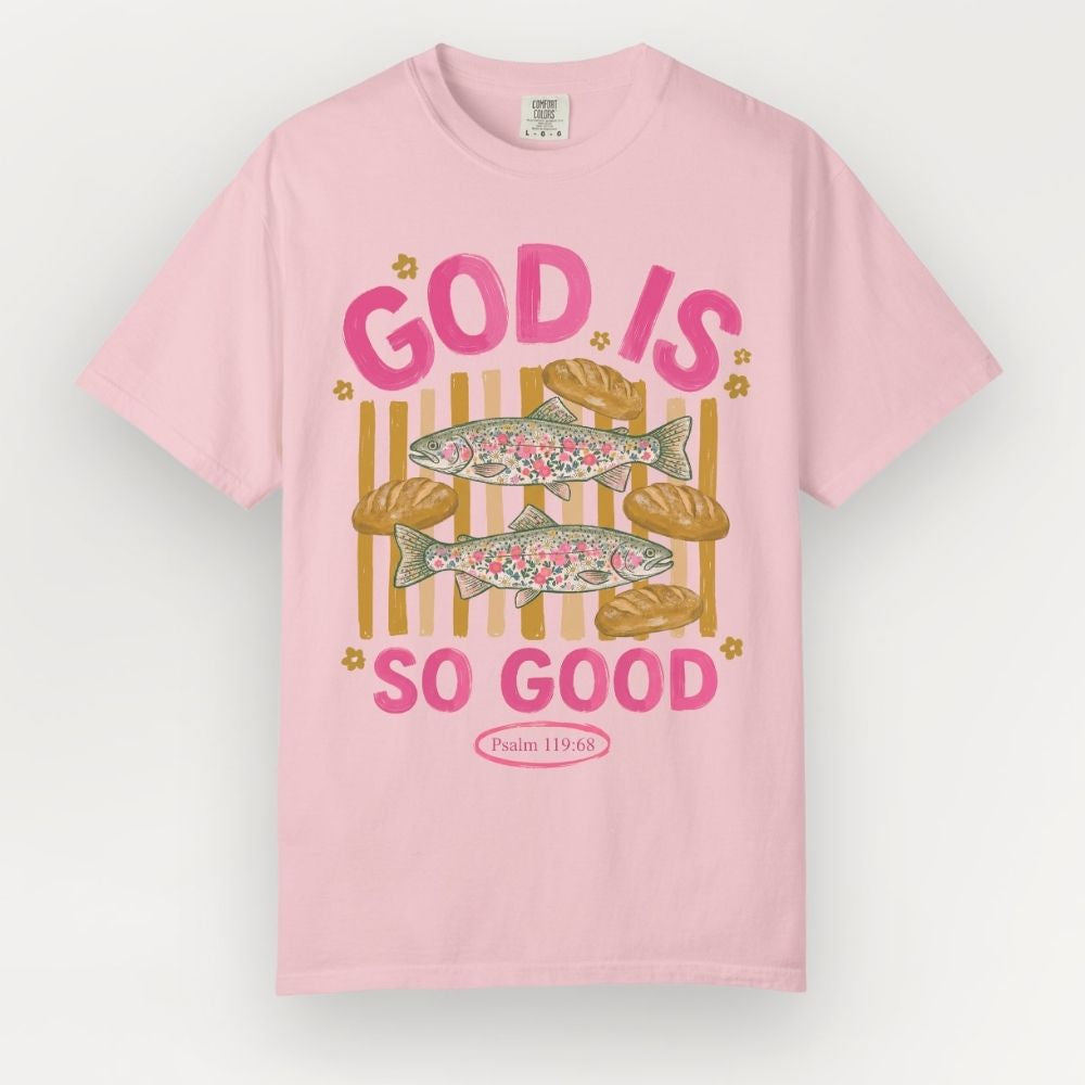 Pink t-shirt with fish and bread graphic and 'God is so good' text on a white background