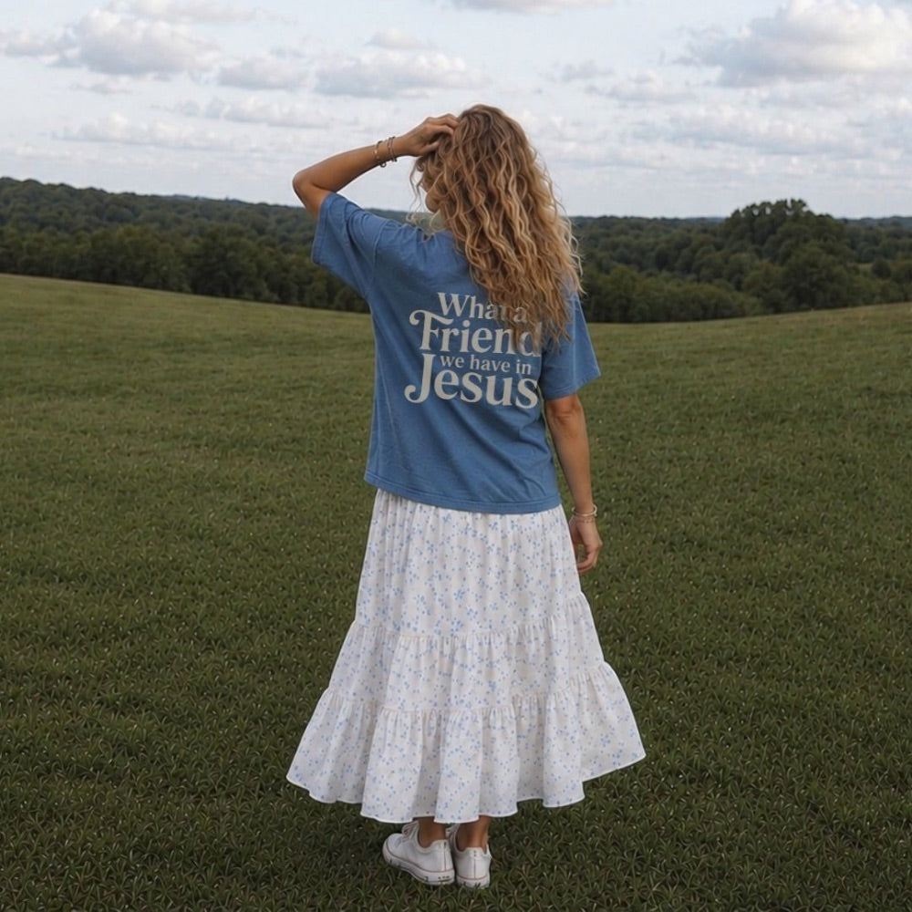 Woman wearing a blue t-shirt with text standing in a grassy field