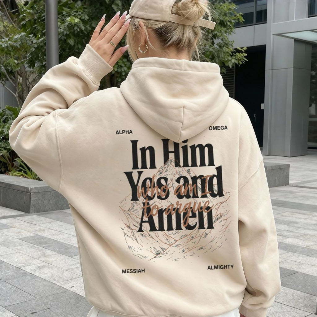 Person wearing a beige hoodie with text on the back, standing outdoors.