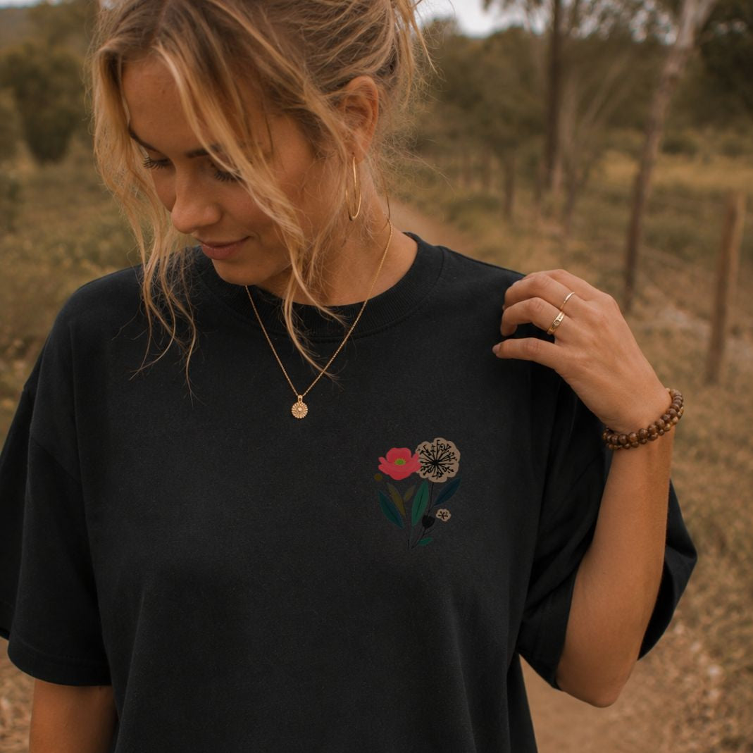 Woman wearing a black t-shirt with floral embroidery outdoors