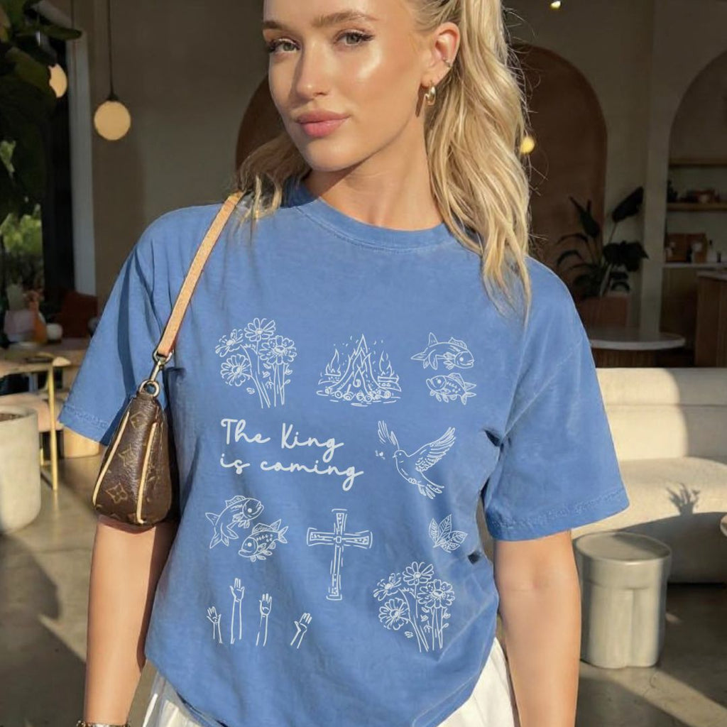 Blue faith inspired t-shirt featuring Christian symbols and the phrase The King is coming inspired by Revelation 22:12