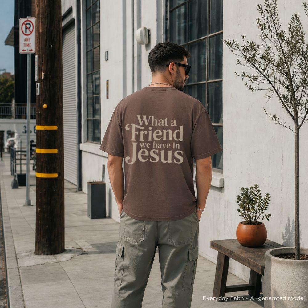 Man wearing a brown t-shirt with text on the back, standing on a sidewalk.