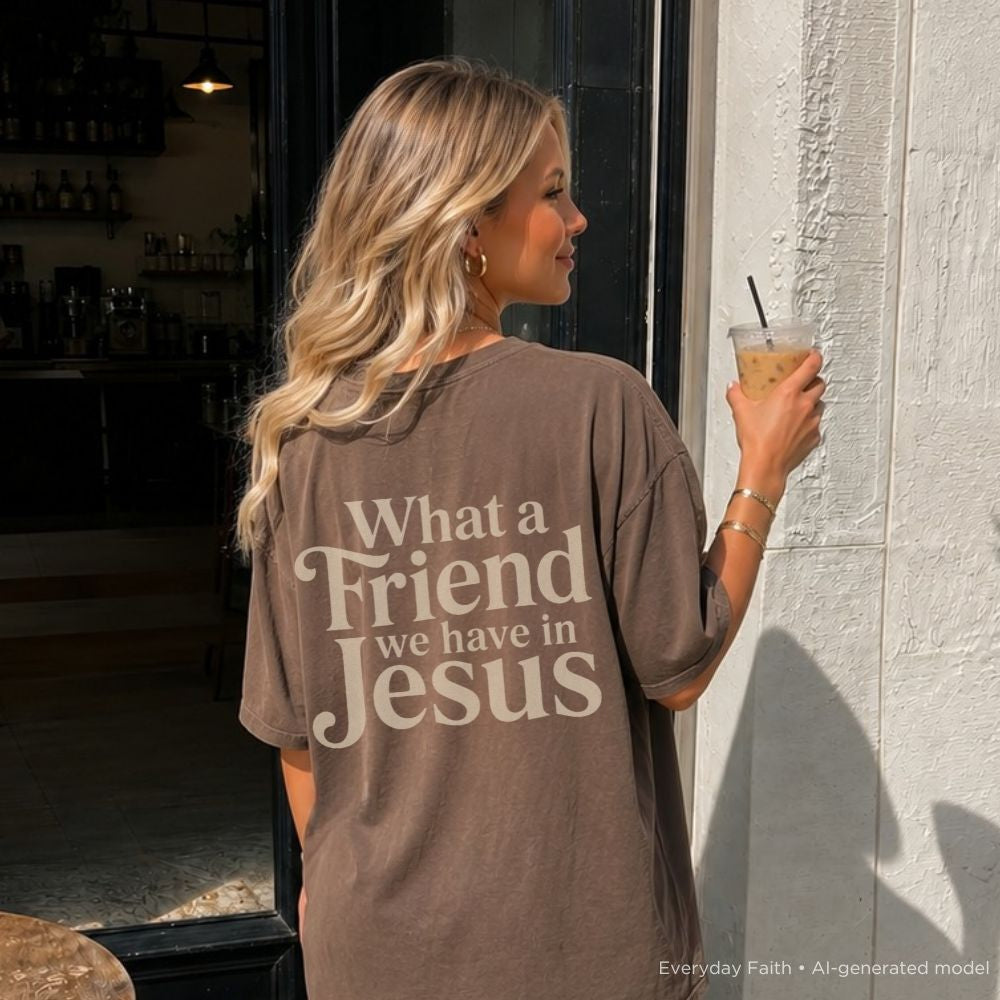 Woman wearing a brown t-shirt with text, holding a drink outside a building.