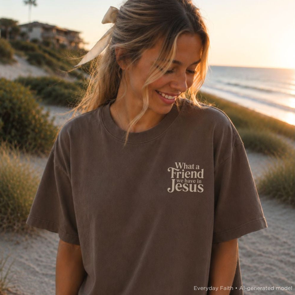 Woman wearing a brown t-shirt with text on the beach at sunset