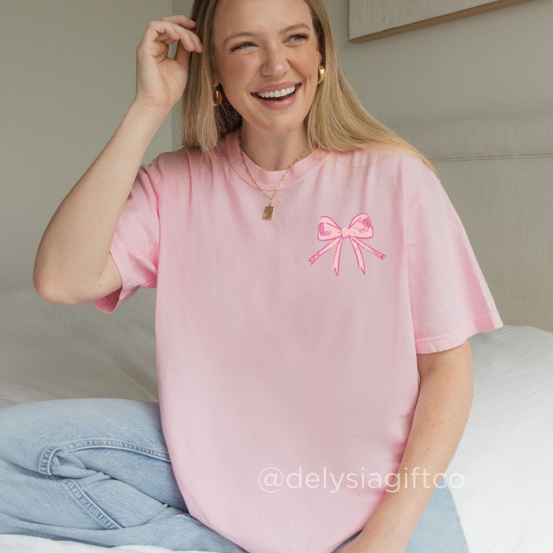 Woman wearing pink God Says You Are Christian t-shirt with bow graphics and uplifting faith affirmations on the back.