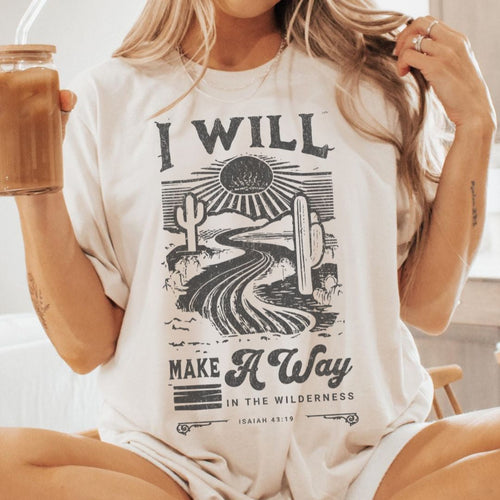 Woman wearing a Christian t-shirt with “I Will Make a Way” Isaiah 43:19 text design outdoors.