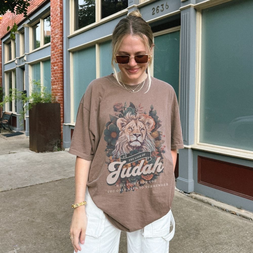 Woman wearing a Lion of Judah Christian t-shirt artwork with lion illustration and scripture text